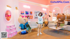 A woman posing in front of a teddy bear in a store.