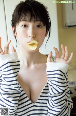 A woman in a white bikini posing on a kitchen counter.
