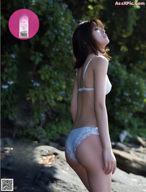 A woman in a white dress is posing for a magazine cover.