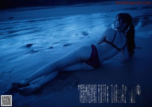 A woman in a purple bra is looking up at the sky.