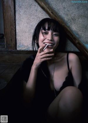A woman in a black lingerie leaning against a window.