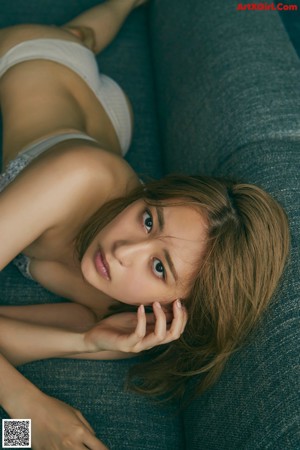 A woman in a gray lingerie leaning against a door.