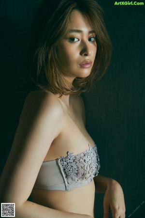 A woman in a blue bra and red panties standing in front of a mirror.