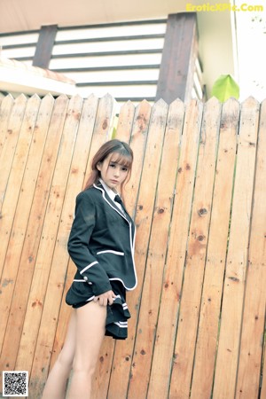 A woman in a school uniform standing in a field.