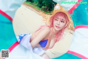 A woman in a bikini and a straw hat posing for a magazine.