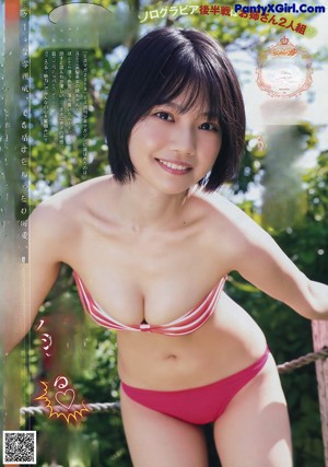 A woman in a white bikini sitting on a bed.
