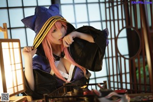 A woman with pink hair sitting at a table.