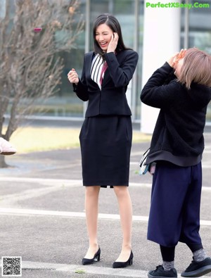 A woman with long black hair wearing a black top.