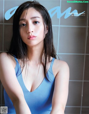 A woman in a white shirt is posing for a magazine.