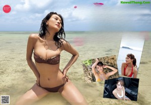 A woman in a red bikini sitting on a beach.