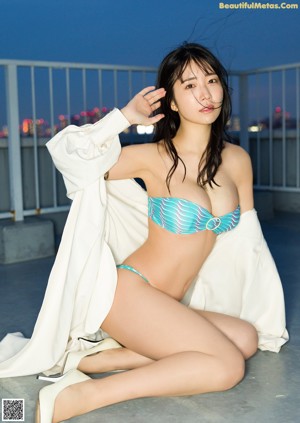 A woman in a bikini smoking a cigarette.