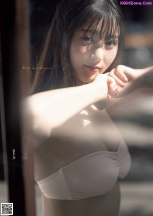 A woman in a white shirt and black bra posing for a picture.