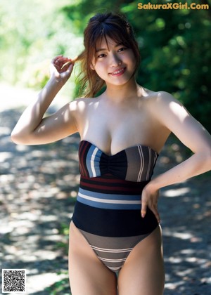 A naked asian woman sitting on a window sill.