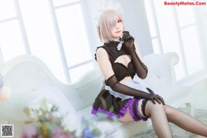 A woman in a maid outfit posing for a picture.