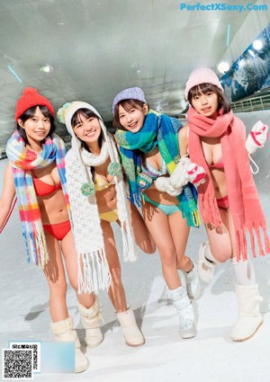 A group of women in bikinis sitting on a bed next to a fireplace.