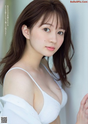 A woman in a white shirt is posing for a picture.