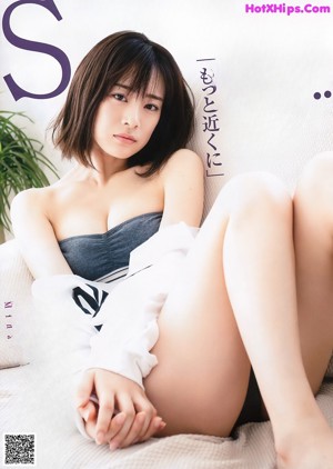 A woman sitting on top of a white couch.