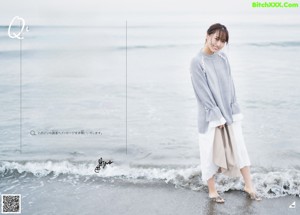 A woman running on a sandy beach with a white dress.